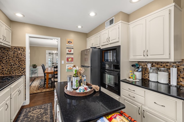 kitchen with white cabinetry, black appliances, dark hardwood / wood-style flooring, decorative backsplash, and a chandelier