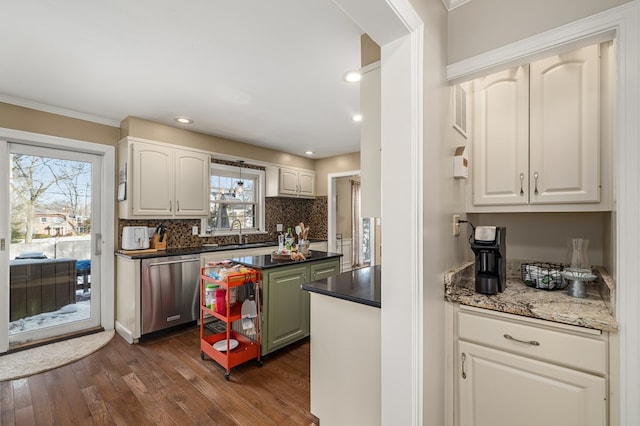 kitchen with sink, white cabinets, dark hardwood / wood-style flooring, decorative backsplash, and stainless steel dishwasher