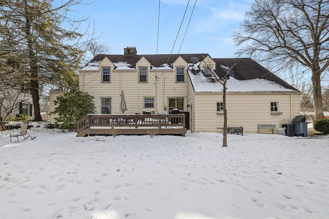 snow covered property with a deck