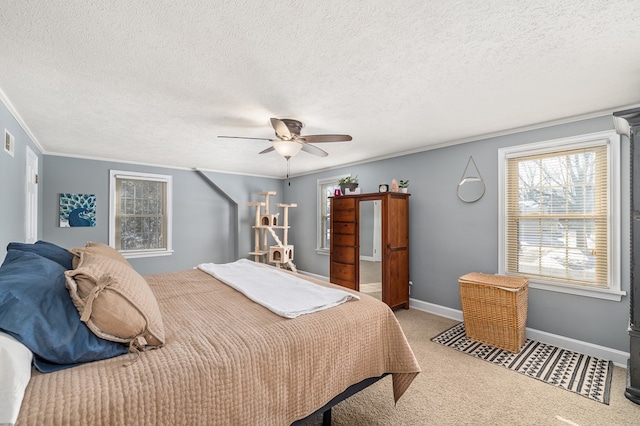 bedroom featuring crown molding, carpet floors, a textured ceiling, and ceiling fan