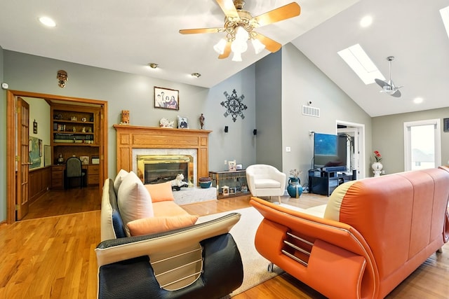 1515 Oak Run Ct, Mansfield, OH 44906 - living area featuring ceiling fan, a skylight, a premium fireplace, high vaulted ceiling, and light wood finished floors