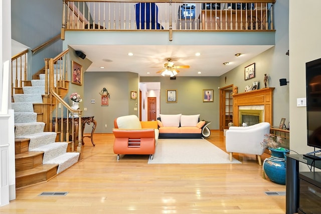 1515 Oak Run Ct, Mansfield, OH 44906 - living area with a towering ceiling, stairs, a premium fireplace, wood finished floors, and a ceiling fan