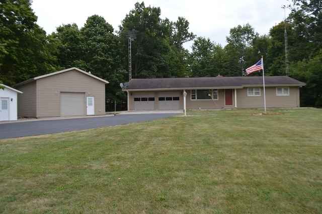 view of front of home with a front lawn, an outdoor structure, and a garage