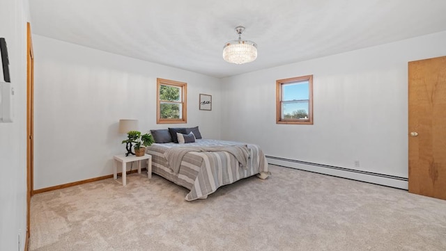 carpeted bedroom featuring an inviting chandelier and a baseboard heating unit