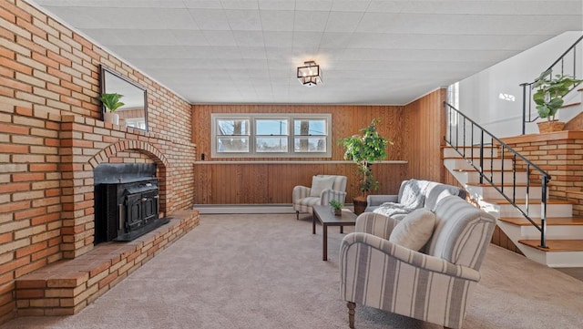 living room featuring baseboard heating, a wood stove, wooden walls, and light carpet