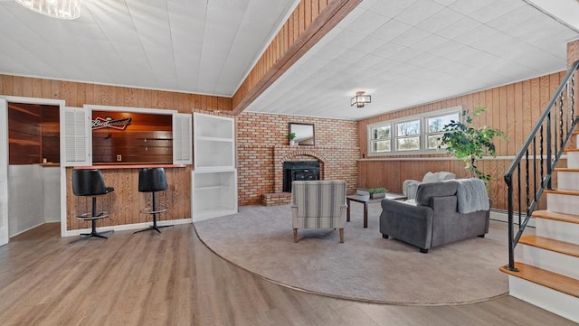 living room with hardwood / wood-style floors, bar, wooden walls, and a baseboard heating unit