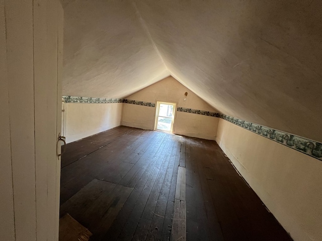 bonus room with dark hardwood / wood-style flooring and lofted ceiling