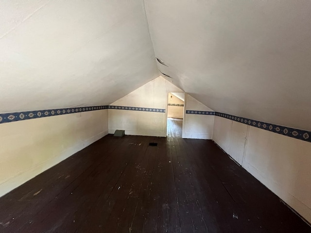 additional living space with dark hardwood / wood-style floors and vaulted ceiling