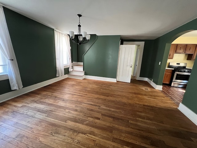 unfurnished dining area with a chandelier and dark hardwood / wood-style flooring