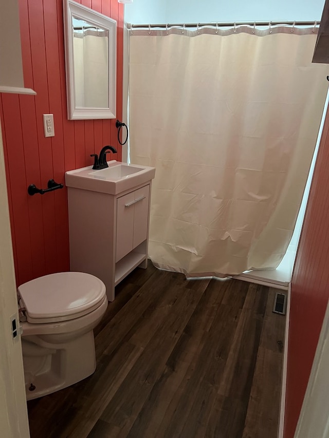 bathroom with curtained shower, toilet, vanity, and hardwood / wood-style flooring