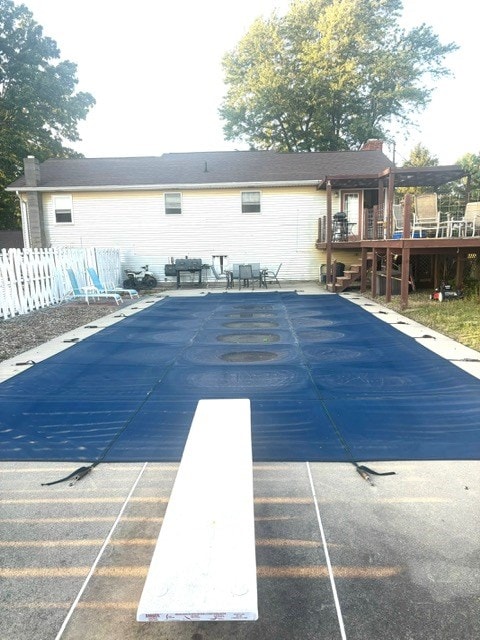 view of pool featuring a diving board and a wooden deck
