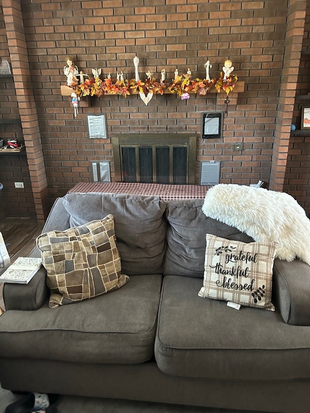 living room featuring brick wall and a brick fireplace