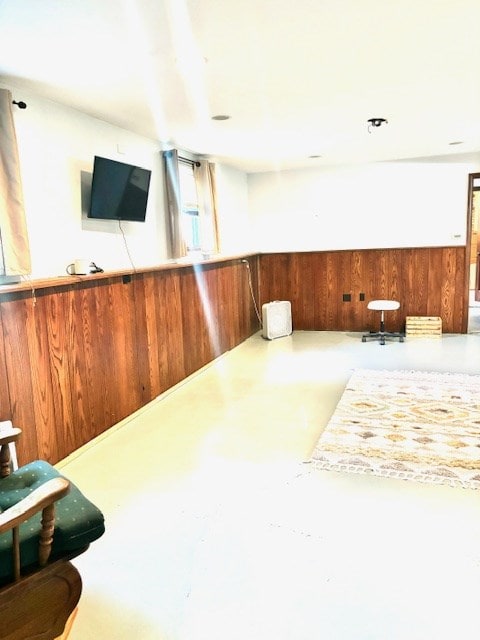 interior space featuring wooden walls and concrete floors