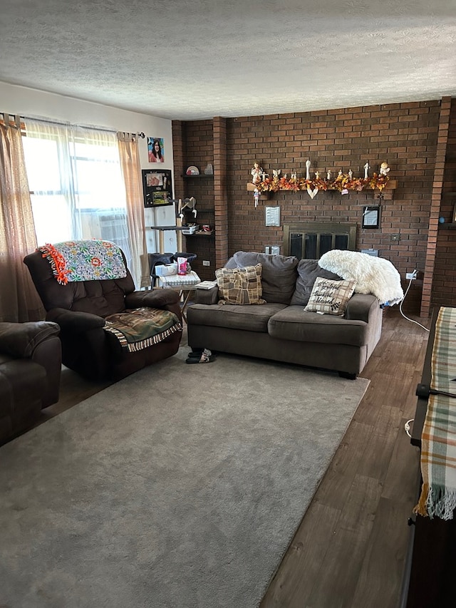 living room with dark hardwood / wood-style flooring, a textured ceiling, and a brick fireplace