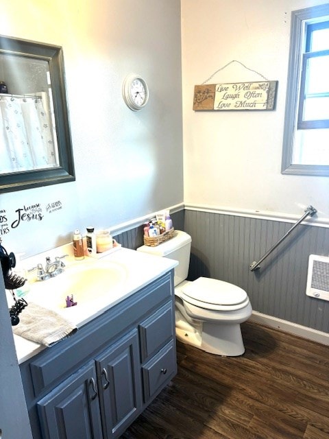 bathroom featuring wood walls, vanity, wood-type flooring, and toilet