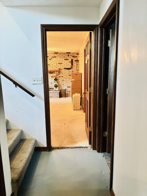 hallway with concrete floors and brick wall
