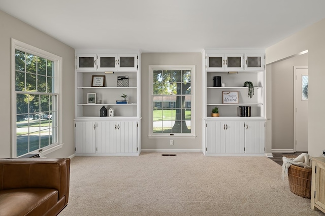 sitting room featuring plenty of natural light and light colored carpet