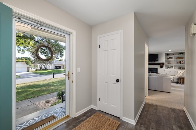 foyer entrance with a fireplace and dark hardwood / wood-style floors