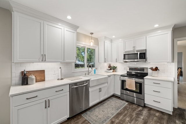 kitchen featuring pendant lighting, sink, white cabinets, and stainless steel appliances