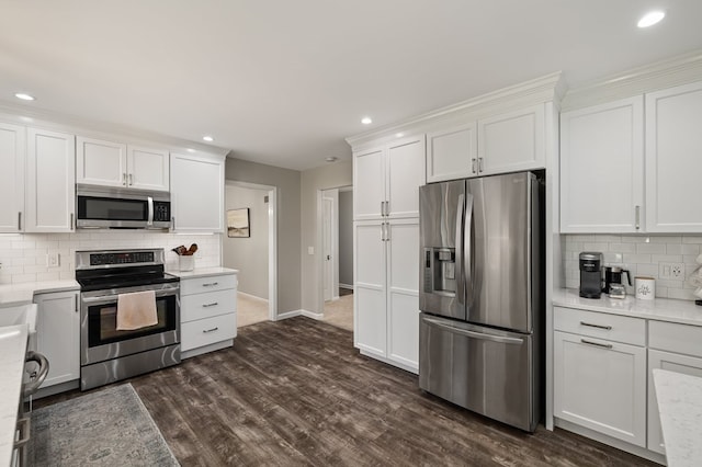 kitchen with backsplash, stainless steel appliances, and white cabinetry