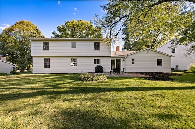 rear view of house featuring a yard and a patio