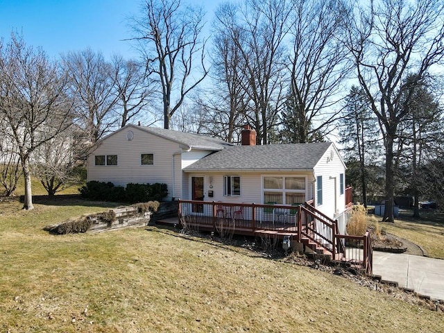 view of front facade featuring a deck, a front lawn, a shingled roof, and a chimney