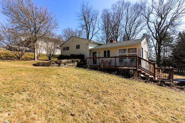 rear view of house with a wooden deck, a lawn, and a chimney