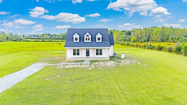 cape cod house with a porch, a front yard, and a rural view