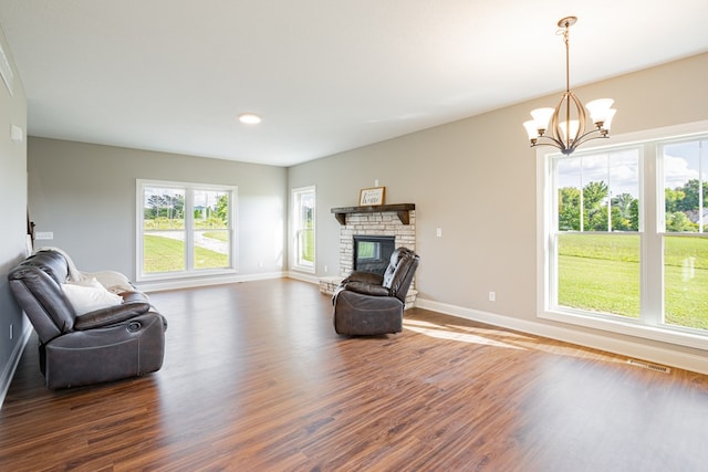 living room featuring a fireplace, dark hardwood / wood-style flooring, and a notable chandelier