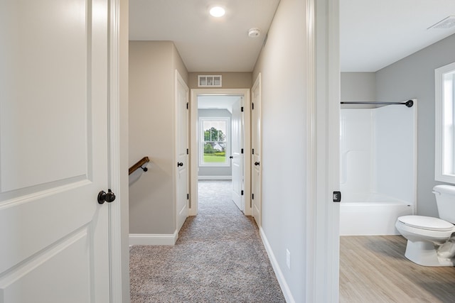 hall with light colored carpet