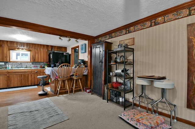 28 W Main St, Hayesville, OH 44838 - kitchen with a sink, brown cabinets, a textured ceiling, black fridge, and light countertops