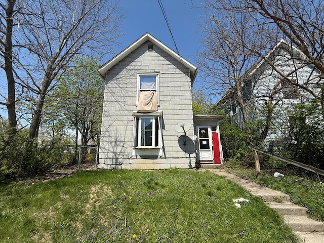 view of front facade with a front lawn and fence