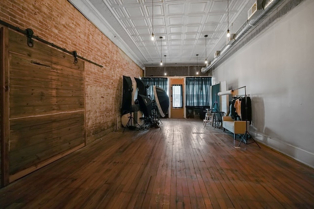 38 E Main St, Shelby, OH 44875 - exercise room with brick wall, wood-type flooring, and a barn door