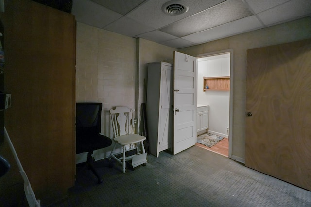 38 E Main St, Shelby, OH 44875 - bedroom featuring concrete block wall, a drop ceiling, and connected bathroom