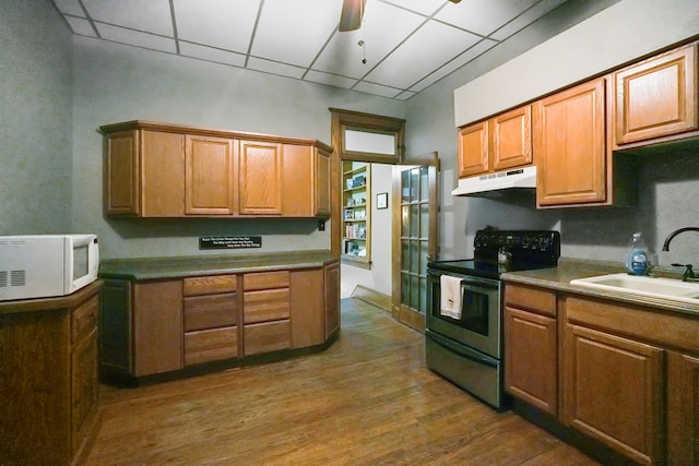 38 E Main St, Shelby, OH 44875 - kitchen with stainless steel range with electric stovetop, white microwave, under cabinet range hood, a drop ceiling, and dark wood-style flooring