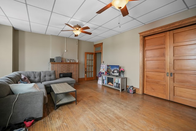 38 E Main St, Shelby, OH 44875 - living area with a ceiling fan, a fireplace, a drop ceiling, and light wood-style floors