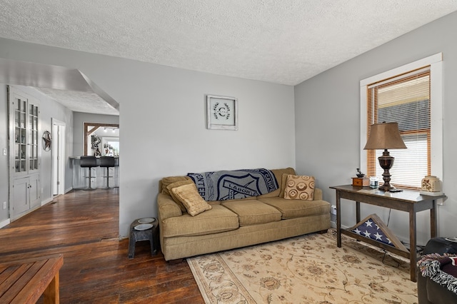 living room featuring dark hardwood / wood-style floors and a textured ceiling