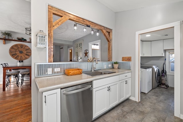 kitchen with dishwasher, separate washer and dryer, white cabinetry, and sink