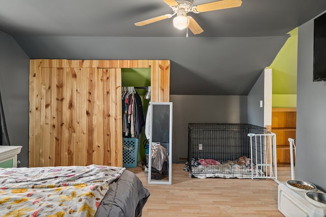 bedroom with light hardwood / wood-style floors, a closet, lofted ceiling, and ceiling fan