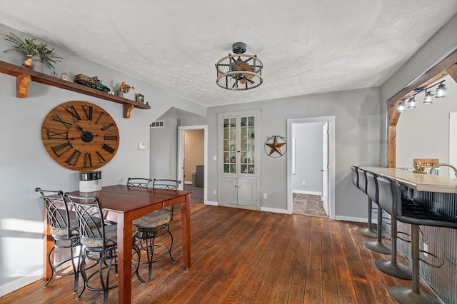 dining space featuring dark hardwood / wood-style flooring and a textured ceiling