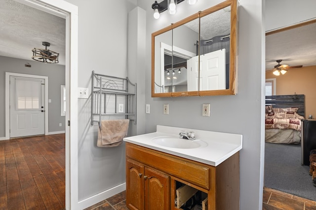 bathroom featuring vanity, wood-type flooring, a textured ceiling, and ceiling fan