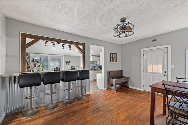 kitchen featuring white cabinets, hardwood / wood-style floors, and a textured ceiling