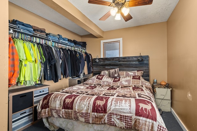 bedroom featuring beam ceiling, carpet floors, a textured ceiling, and ceiling fan