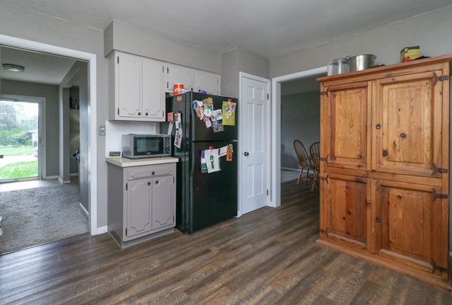 468 Clearview Rd, Mansfield, OH 44907 - kitchen with freestanding refrigerator, stainless steel microwave, dark wood-type flooring, white cabinetry, and light countertops