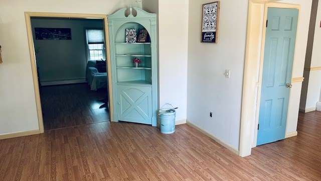 920 Woodbine St, Willard, OH 44890 - unfurnished room with wood finished floors and a baseboard heating unit