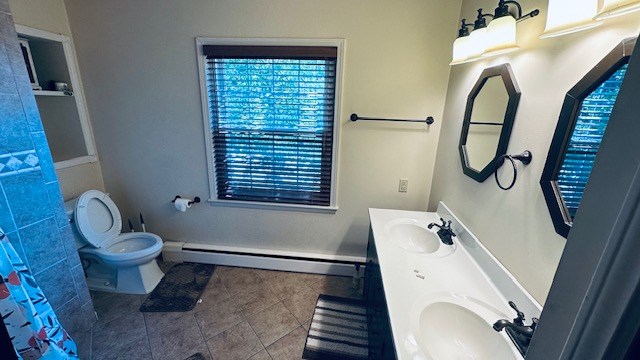 920 Woodbine St, Willard, OH 44890 - bathroom with baseboard heating, double vanity, and tile patterned flooring