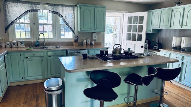 920 Woodbine St, Willard, OH 44890 - kitchen featuring dishwasher, a center island, a breakfast bar, and plenty of natural light