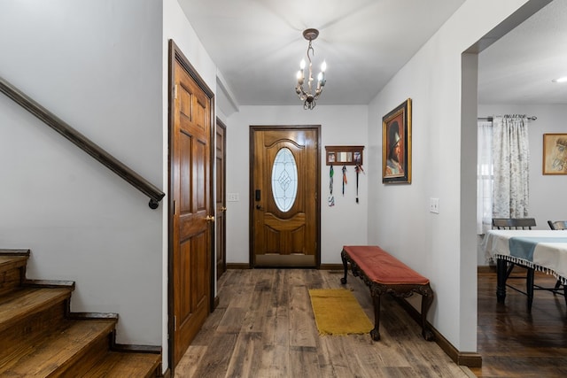 entryway with dark wood-type flooring and an inviting chandelier