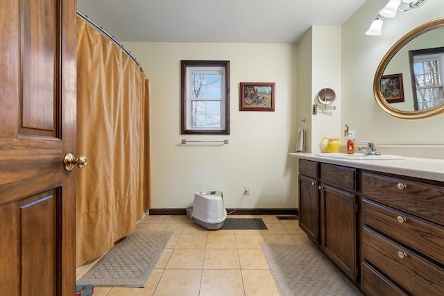 bathroom with tile patterned flooring, vanity, and a healthy amount of sunlight