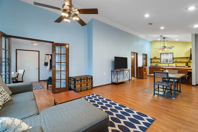 living room featuring french doors, ceiling fan, wood-type flooring, and high vaulted ceiling